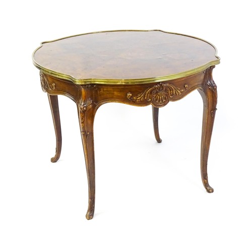 1341 - A late 19thC / early 20thC walnut centre table with a shaped top and a gilt surround, the table havi... 