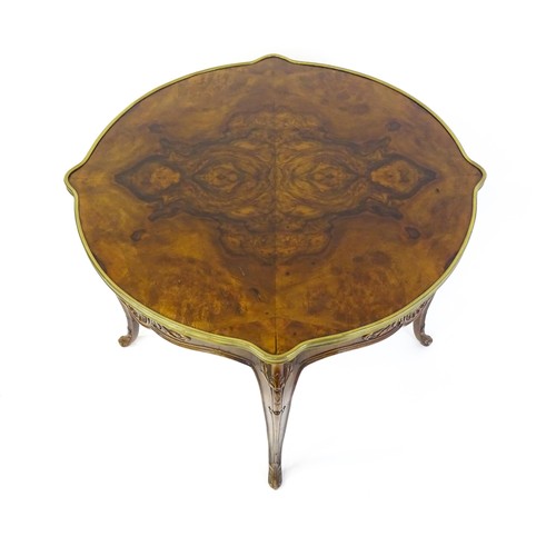 1341 - A late 19thC / early 20thC walnut centre table with a shaped top and a gilt surround, the table havi... 