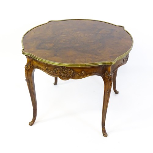 1341 - A late 19thC / early 20thC walnut centre table with a shaped top and a gilt surround, the table havi... 