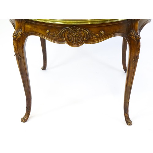 1341 - A late 19thC / early 20thC walnut centre table with a shaped top and a gilt surround, the table havi... 