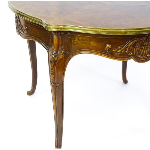 1341 - A late 19thC / early 20thC walnut centre table with a shaped top and a gilt surround, the table havi... 