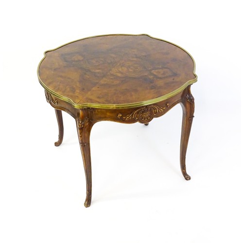 1341 - A late 19thC / early 20thC walnut centre table with a shaped top and a gilt surround, the table havi... 