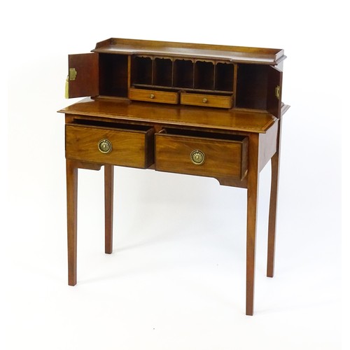 1342 - A late 19thC mahogany writing desk with pigeon holes, cupboards and drawers mounted above a crossban... 