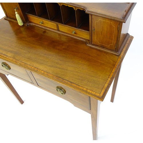 1342 - A late 19thC mahogany writing desk with pigeon holes, cupboards and drawers mounted above a crossban... 