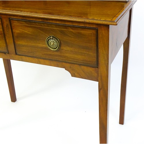 1342 - A late 19thC mahogany writing desk with pigeon holes, cupboards and drawers mounted above a crossban... 