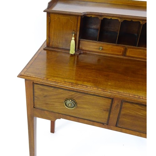 1342 - A late 19thC mahogany writing desk with pigeon holes, cupboards and drawers mounted above a crossban... 