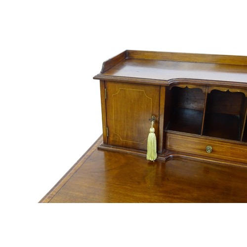 1342 - A late 19thC mahogany writing desk with pigeon holes, cupboards and drawers mounted above a crossban... 