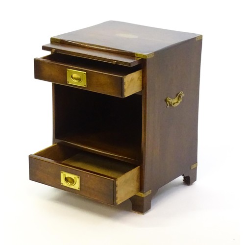 1344 - A mid / late 20thC campaign style cabinet with brass mounted corners, a pull out slide, and two shor... 