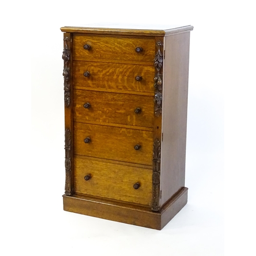 1346 - A Victorian oak Wellington chest, with a moulded top above five graduated drawers with stylised acor... 