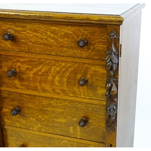 1346 - A Victorian oak Wellington chest, with a moulded top above five graduated drawers with stylised acor... 