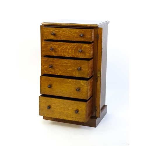 1346 - A Victorian oak Wellington chest, with a moulded top above five graduated drawers with stylised acor... 