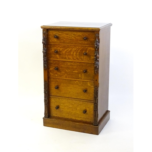 1346 - A Victorian oak Wellington chest, with a moulded top above five graduated drawers with stylised acor... 