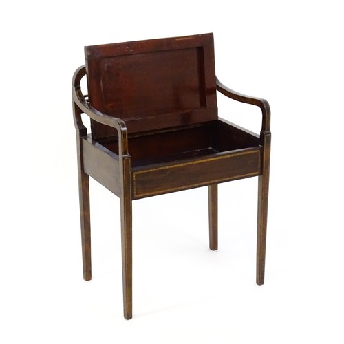 1348 - An early 20thC piano stool with a shaped, carved backrest, pierced back splat and a hinged upholster... 