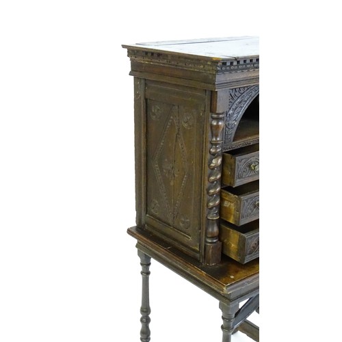 1349 - A Victorian oak cabinet on stand. A 19thC table cabinet with carved lozenge decoration , six short d... 