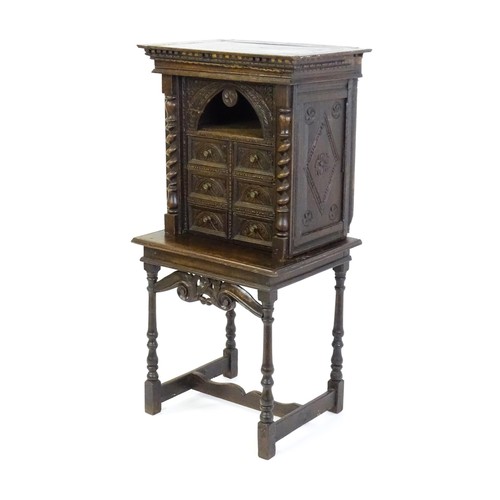 1349 - A Victorian oak cabinet on stand. A 19thC table cabinet with carved lozenge decoration , six short d... 