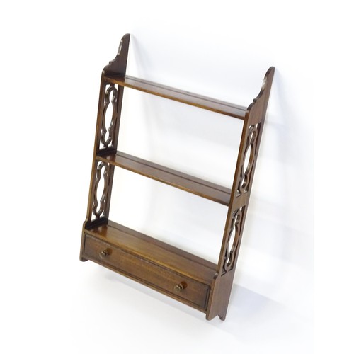 1354 - A set of mid 20thC mahogany wall shelves with three tiers and pierced, carved sides, the shelves hav... 