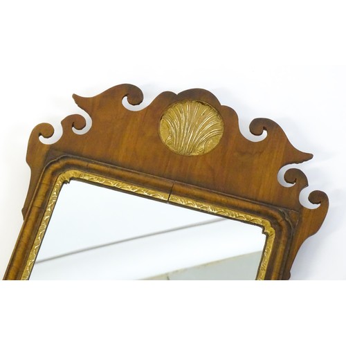 1356 - A mid 20thC George III style walnut mirror with a gilt shell and gilt moulded decoration. 16