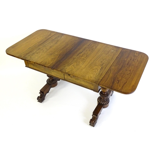 1358 - An early / mid 19thC rosewood sofa table, with drop flaps to either side and two frieze drawers with... 