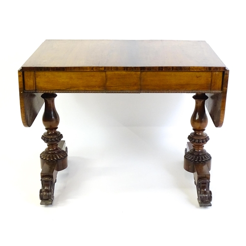 1358 - An early / mid 19thC rosewood sofa table, with drop flaps to either side and two frieze drawers with... 