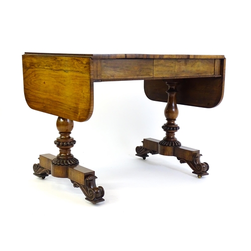 1358 - An early / mid 19thC rosewood sofa table, with drop flaps to either side and two frieze drawers with... 