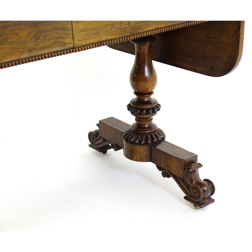 1358 - An early / mid 19thC rosewood sofa table, with drop flaps to either side and two frieze drawers with... 