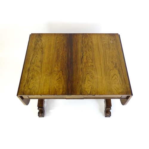 1358 - An early / mid 19thC rosewood sofa table, with drop flaps to either side and two frieze drawers with... 