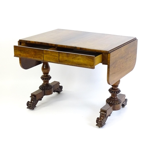 1358 - An early / mid 19thC rosewood sofa table, with drop flaps to either side and two frieze drawers with... 