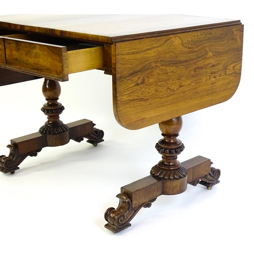 1358 - An early / mid 19thC rosewood sofa table, with drop flaps to either side and two frieze drawers with... 