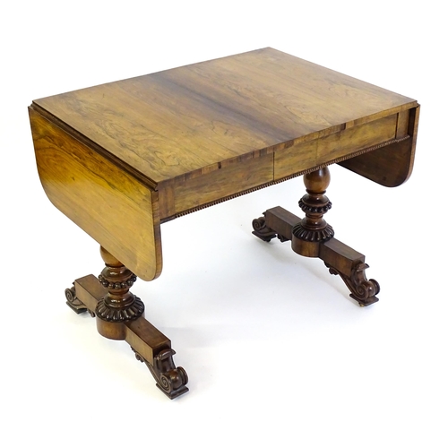 1358 - An early / mid 19thC rosewood sofa table, with drop flaps to either side and two frieze drawers with... 