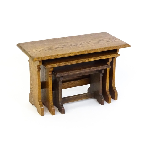 1359 - An oak Cotswold school nest of tables with carved edges, shaped supports and H - stretchers. 28