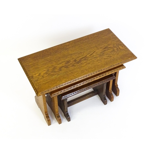 1359 - An oak Cotswold school nest of tables with carved edges, shaped supports and H - stretchers. 28