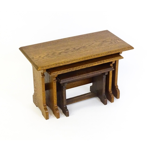 1359 - An oak Cotswold school nest of tables with carved edges, shaped supports and H - stretchers. 28