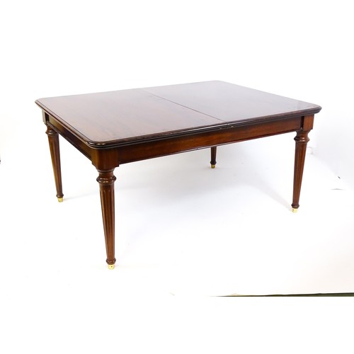 1363 - A late 20thC mahogany dining table with two additional leaves. The moulded table top raised on four ... 