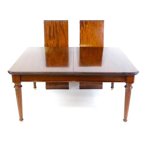 1363 - A late 20thC mahogany dining table with two additional leaves. The moulded table top raised on four ... 