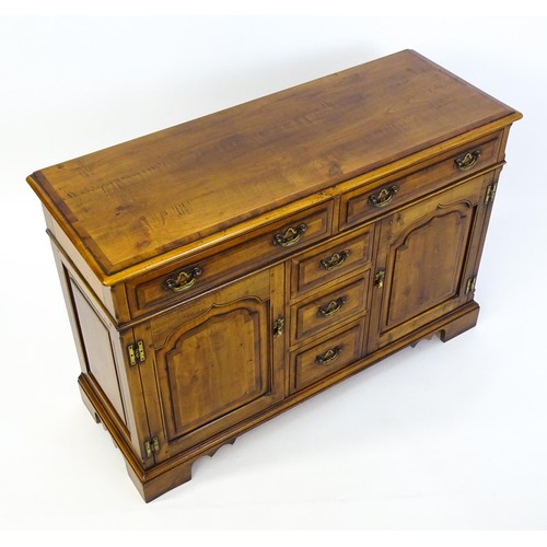 1364 - A 20thC sideboard / dresser base with a crossbanded top and two long over three short drawers flanke... 