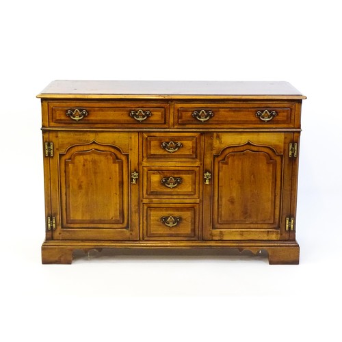 1364 - A 20thC sideboard / dresser base with a crossbanded top and two long over three short drawers flanke... 