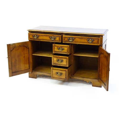 1364 - A 20thC sideboard / dresser base with a crossbanded top and two long over three short drawers flanke... 