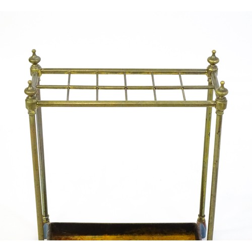 1365 - A late 19thC brass stick stand surmounted by turned finials and with twelve sections above a drip tr... 