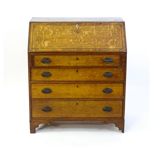 1372 - An 18thC oak bureau with a crossbanded fall front containing a fitted interior with small drawers, c... 