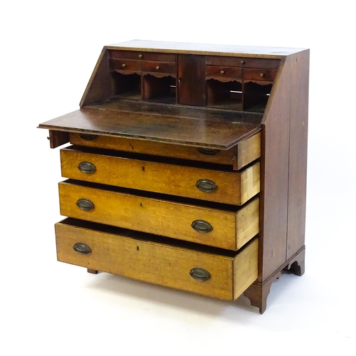 1372 - An 18thC oak bureau with a crossbanded fall front containing a fitted interior with small drawers, c... 