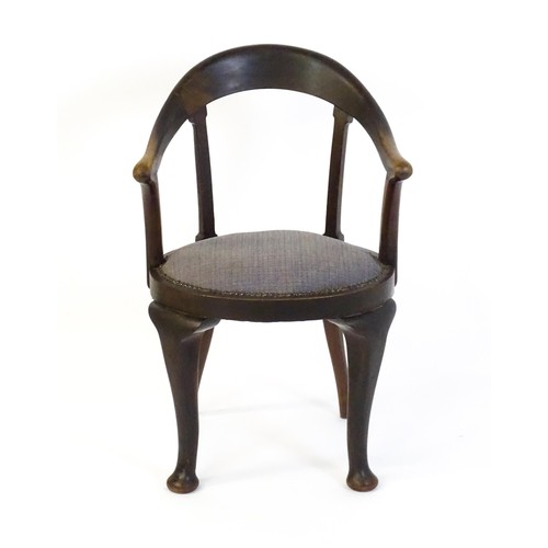 1374 - An early 20thC bow back armchair, with a shaped and bowed top rail above a circular seat and raised ... 