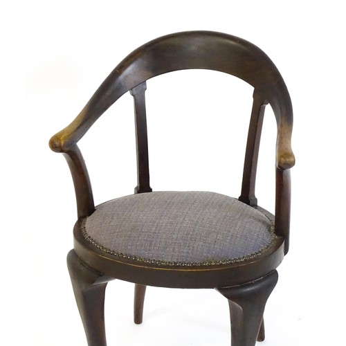 1374 - An early 20thC bow back armchair, with a shaped and bowed top rail above a circular seat and raised ... 