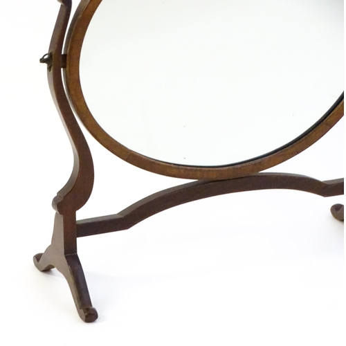 1375 - An early 20thC mahogany skeleton mirror / toilet mirror with an oval surround raised on shaped suppo... 