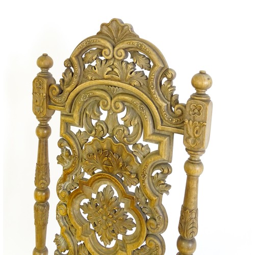 1378 - A 20thC Carolean style armchair, with a carved and pierced backrest, floral decoration, turned taper... 