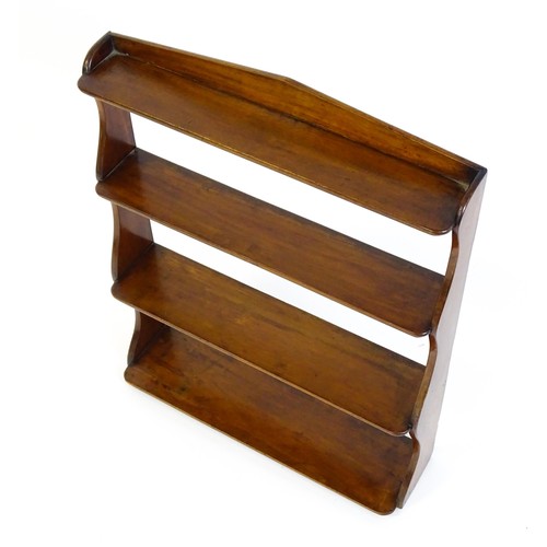 1382 - A late 19thC mahogany set of hanging wall shelves with a pointed upstand above shaped sides and grad... 