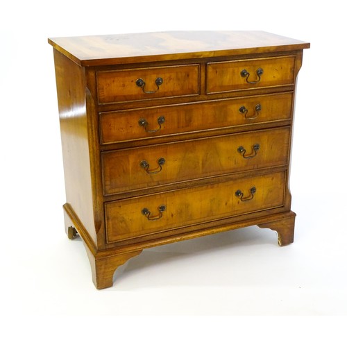 1384 - A yew wood veneered chest of drawers, with a rectangular crossbanded top above two short over three ... 