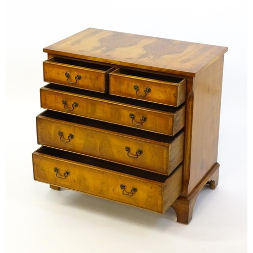 1384 - A yew wood veneered chest of drawers, with a rectangular crossbanded top above two short over three ... 