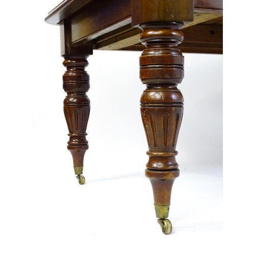 1391 - An early 20thC mahogany extending dining table, with a moulded top above four turned tapering legs w... 