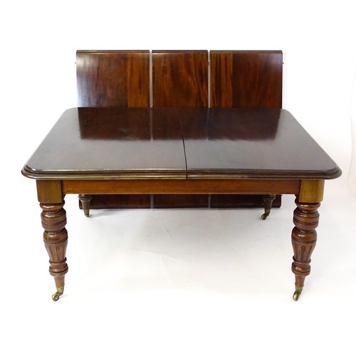 1391 - An early 20thC mahogany extending dining table, with a moulded top above four turned tapering legs w... 