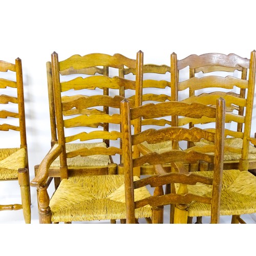 1392 - A group of eight mid 20thC oak dining chairs, with ladderbacks, envelope rush seats and raised on ta... 